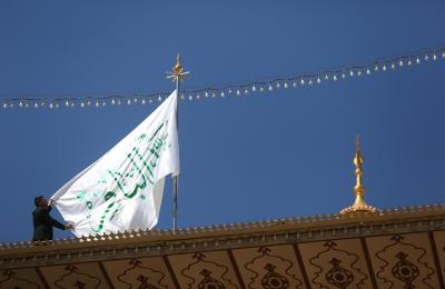 استبدال راية قبة مرقد أمير المؤمنين (عليه السلام)، براية باقر علوم الأولين والآخرين احتفاء بذكرى ولادته العطرة (صلوات الله وسلامه عليه)