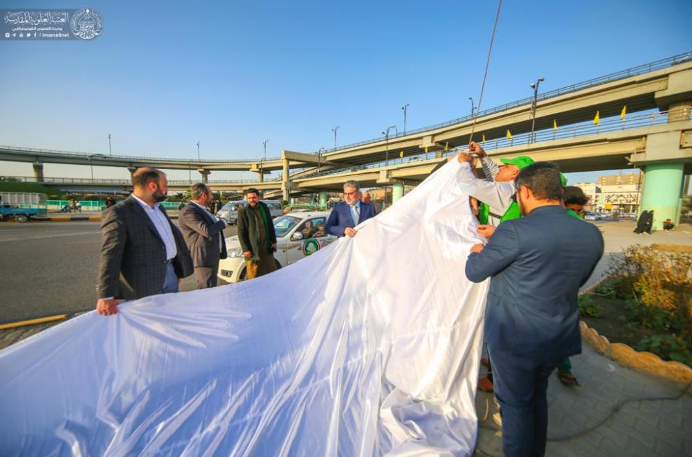 رفع راية (محمدٌ وعلي قدوتنا) في مركز مدينة النجف الأشرف ضمن الاستعدادات الخاصة لإحياء مناسبة الولادة الميمونة للمولى أمير المؤمنين (عليه السلام)